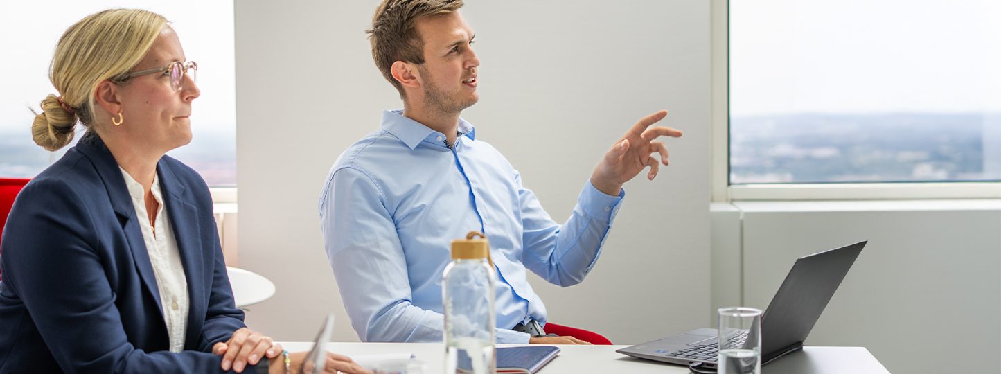 Ein Geschäftstreffen oder eine Besprechung in einem Büro, bei dem ein Laptop, Getränkeflaschen und Wassergläser auf einem Tisch stehen.