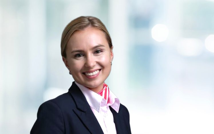 Die Person trägt ein formelles Outfit, bestehend aus einem schwarzen Blazer und einem rot-weiß gestreiften Hemd.